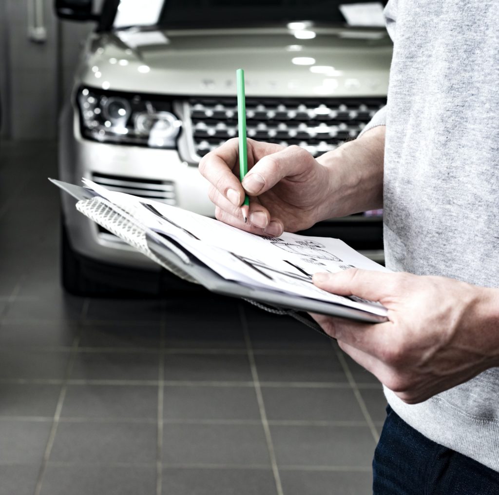 Mechanic writing to the clipboard at workshop warehouse